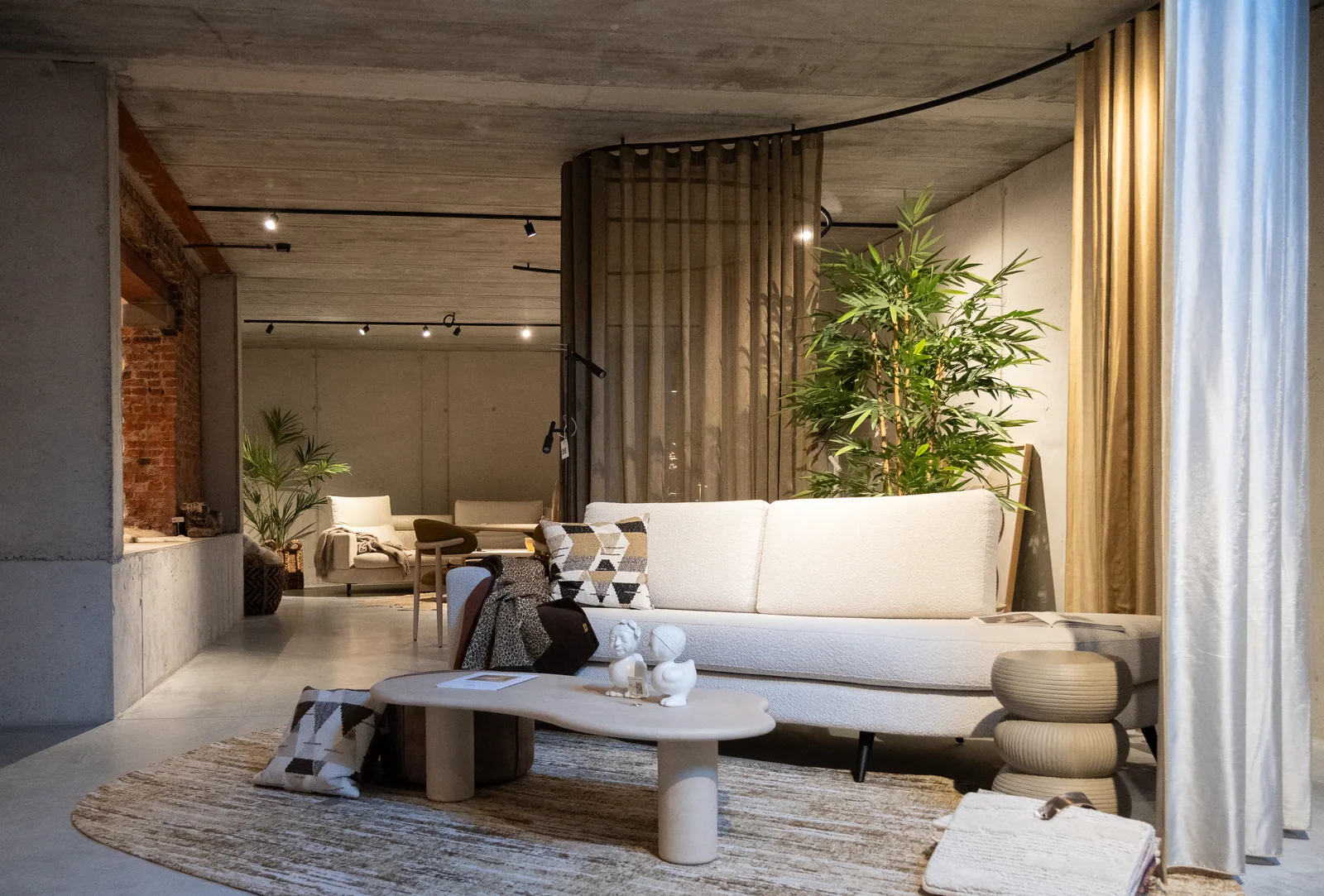 Showroom op niveau -1 met baksteen, beton en gordijnen